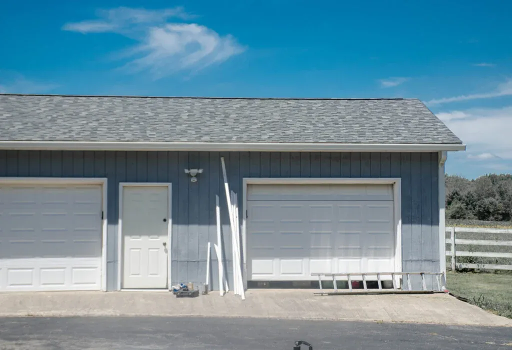Garage exterior with two garage doors under a clear blue Texas sky